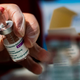 A Red Cross volunteer handles a dose of the AstraZeneca vaccine in a vaccination site set up at Rome’s Fiumicino airport long-term parking area.
